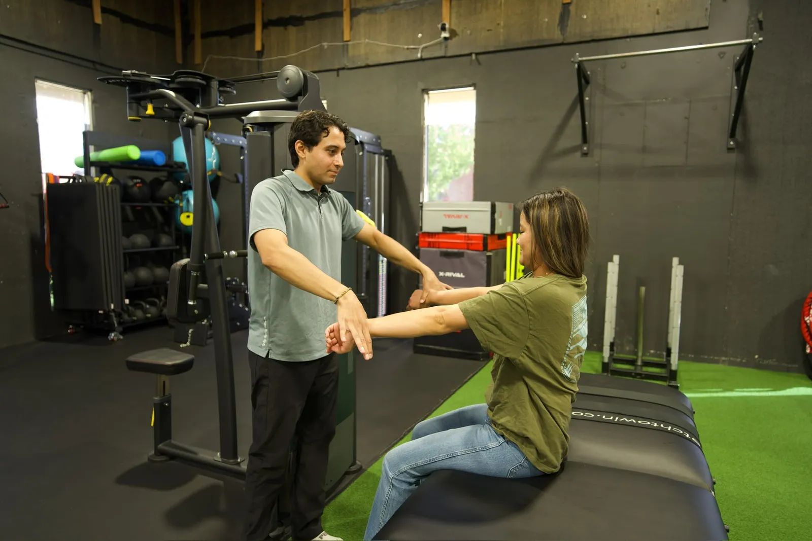 Physiotherapist guiding a seated patient through a supported arm exercise